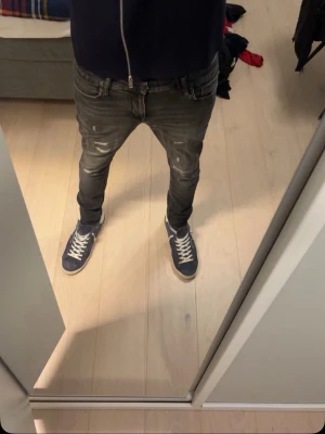 Grå slitna slim fit jeans från Jack & Jones  - Säljer ett par grå slim fit jeans från Jack & jones med slitningar och distressed detaljer. Jeansen har klassisk femficksmodell, låg midja och smal passform. Perfekta för en trendig och avslappnad stil.