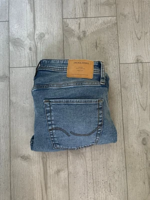Jack and Jones Jeans - Tja, säljer dessa Jack and Jones jeans i modellen Regular/Clark. Storleken på jeansen ligger på 31/34. Jeansen är aldrig använda, de har bara blivit tvättade 1 gång (därför finns ej etikett).