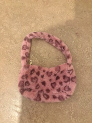 pink fluffy leopard/heart-print underarm bag - This bag has a fluffy material, it's really comfortable to hold and hang around your arm and shoulder. It's quite light — there was no label inside the bag though, but oh well. This bag is unused, I've never gone out with it, and it fits perfectly with a Y2K style or something else. The measurements are Width: 27 cm (10.6 inches)Height: 15 cm (5.9 inches)Thickness/Depth: 3 cm (1.2 inches)  Write to me if you have any questions ☺️