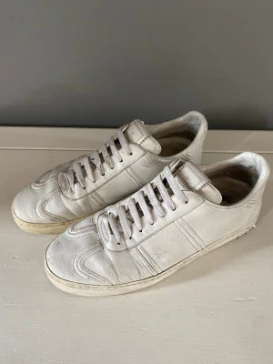 Valentino Flycrews - Säljer ett par stilrena Valentino Garavani sneakers i vitt läder. Klassisk och tidlös modell som passar till i princip allt. Skorna är använda och har normalt slitage i form av veck i lädret samt lite smuts på sulorna (se bilder)                                                          Hör gärna av dig vid frågor eller om du vill ha fler bilder! Går ner i pris vid snabbaffär