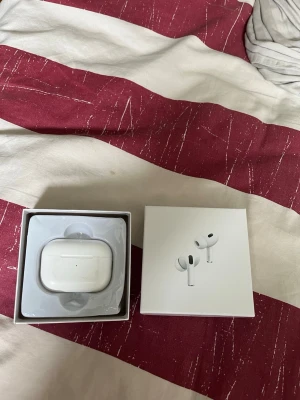 Apple AirPods Pro trådlösa hörlurar - Säljer ett par vita Apple AirPods Pro med laddningsetui. Hörlurarna är trådlösa in-ear-modell och levereras i originalförpackning. Snygg och kompakt design med silikontoppar för bra passform och brusreducering.