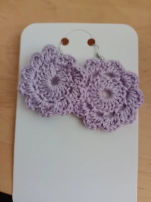 Lila virkade blommiga örhängen - Unika handgjorda örhängen i lila garn, virkade i form av blommor med rundad kant. Perfekta för dig som vill ha en personlig och kreativ accessoar som sticker ut. Krokar i metall för enkel användning.
