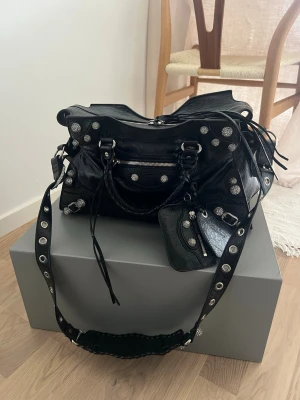 Balenciaga neo cagole city handbag with rhinestones - Slutsåld och aldrig använd, svår att få tag på. Kvitto finns. Inköpt för nästan 30 000kr. Extra diamanter medföljer. Kuvertet på den sista bilden är det enda som inte ingår då returettikett med min adress är där.