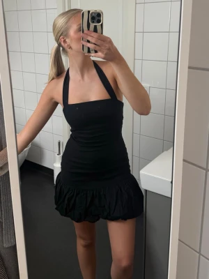 Miniklänning från Zara  - Snygg svart klänning med halterneck och öppen rygg. Klänningen är tight i modellen och har en volang längst ner på kjolen som ger en extra touch. 