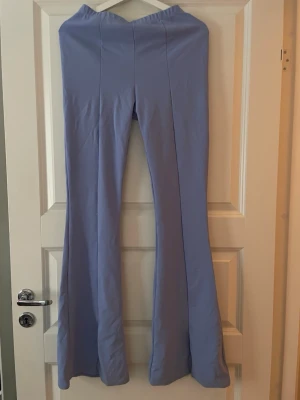 Blå utsvängda leggings - Säljer ett par blå leggings från Boohoo med utsvängda ben och hög midja. Endast testade.