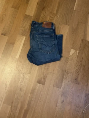 Jack and Jones jeans - Ett par ljusblåa jeans ifrån Jack and Jones i modellen slim/glenn. Jeansen har bara använts ett fåtal gånger och är i mycket bra skick. Pris kan diskuteras.