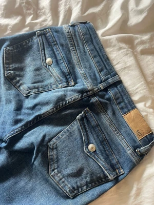 Blå jeans med fickdetaljer - Blåa jeans ifrån lager 157 som inte säljs längre. Modellen heter 90s BOOT och dem är i storlek S full längd. Inga defekter på användning. Pris kan dirkuteras