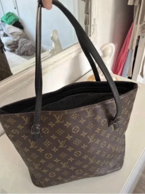 Brun shoppingväska med monogram - Stilren shoppingväska i brunt konstläder med klassiskt monogrammönster . Fint skick. Köpt på vinted men passade inte för mitt användarmål. Pris kan diskuteras . 