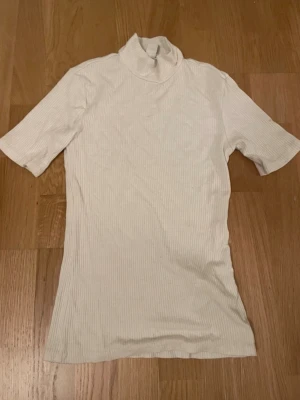 Vit ribbad polotopp - Säljer en vit ribbad polotopp med korta ärmar och hög krage. Skriv för frågor💕