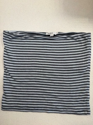 Randig tubtopp från Subdued - Säljer en randig tubtopp från Subdued i blått och svart. Toppen är axelbandslös och har en enkel, tight passform som sitter snyggt. Perfekt att styla med jeans eller kjol för en chill look.