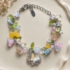 Pastellfärgat armband (handmade)  - Säljer ett armband med pastellfärgade pärlor och blommor. Justerbar kedja i silverfärg. Längd 22cm kan justeras mellan 16-21cm. Passa bra som en present