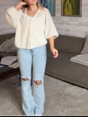 Ljusblå bootcut jeans med slitningar - Säljer ett par ljusblå bootcut jeans med slitningar vid knäna