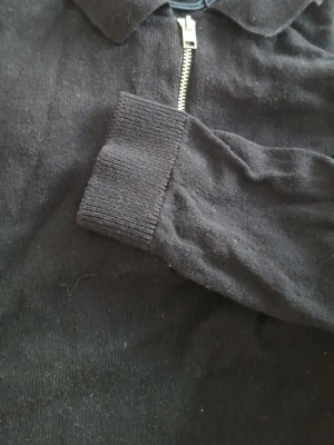 Svart zip hoodie från ASOS DESIGN - Säljer en svart hoodie från ASOS DESIGN i storlek S. Hoodien har dragkedja framtill, ribbade muddar och mjukt, borstat innerfoder. Perfekt för dig som gillar en enkel och stilren look. Materialet känns mjukt och bekvämt mot huden.