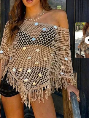 Beige strandponcho med paljetter - Trendig beige strandponcho i nätmaterial med stora silverfärgade paljetter och fransar längs kanten. Ponchon har en avslappnad passform och off-shoulder design, perfekt att slänga över bikinin på stranden. Materialet är lätt och luftigt.