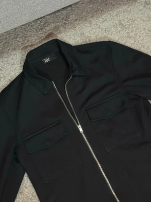 Next Overshirt med Zip Marinblå  - Next overshirt i marinblått med zip framtill. Stilren och lätt att matcha med både jeans och chinos.  Färg: Marinblå Storlek: XS  Fraktar inom 24h vid snabb affär. Byten är inte aktuella.  #Next #Overshirt #Menswear #Streetwear #Fashion
