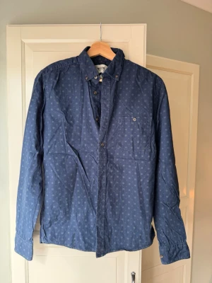 Only & sons skjorta - Snygg blå skjorta med diskret småmönster och klassisk krage. Skjortan har långa ärmar, bröstficka med knapp och knäppning framtill. Perfekt för dig som gillar en avslappnad men ändå stilren look.