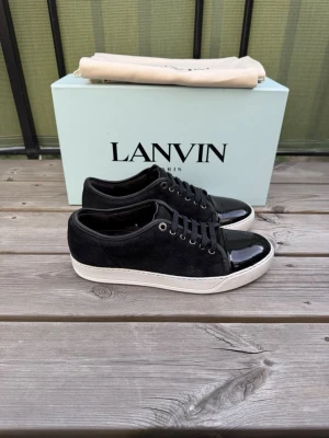 Svarta Lanvin sneakers med lackdetalj - Lanvin dbb 1 | storlek 40 eu | uk 6 | mycket bra skick | defekt på tån se bild | skriv om fler bilder eller prisförslag | obs bara skor som og skickas | obs sulkräm har använts |