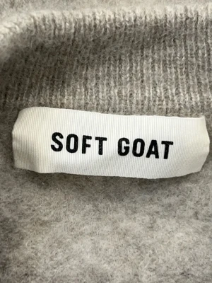 Grå beige stickad tröja från Soft Goat - Mysig grå stickad tröja från Soft Goat i klassisk modell med rund halsringning och ribbade muddar. Tröjan är tillverkad i ett mjukt cashmere utan någon moppen som ger en avslappnad och stilren look. Perfekt för kyliga dagar.❤️