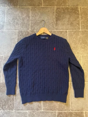 Polo Ralph Lauren stickad tröja – Nyskick -  Säljer en stilren stickad Polo Ralph Lauren-tröja i nyskick. Tröjan är sparsamt använd och har inga fläckar, hål eller andra defekter. Perfekt för både vardag och finare tillfällen.  ✅ Nyskick ✅ 100 % äkta ✅ Klassisk och tidlös design ✅ Skickas snabbt  Hör gärna av dig om du har frågor eller vill ha fler bilder!