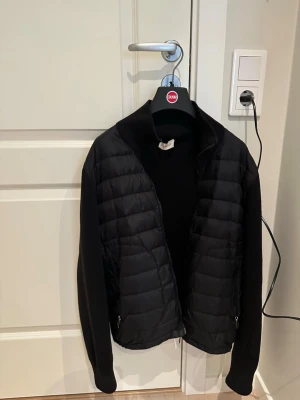 Svart cardigan från Moncler - Snygg svart cardigan från Moncler. Jackan har hög krage, två fickor med dragkedja och en stilren look. Perfekt för kalla dagar och enkel att matcha med olika outfits. Den är i ett bra skick utan större skador som är synliga.⚠️ Priset kan diskuteras vid snabb affär⚠️