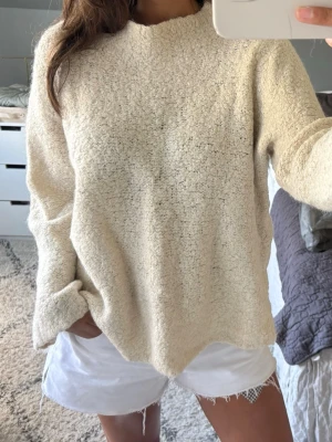 oversized stickad tröja - Mysig cremevit stickad tröja med oversized passform och rund hals. Perfekt att slänga på sig när sena sommarkvällar