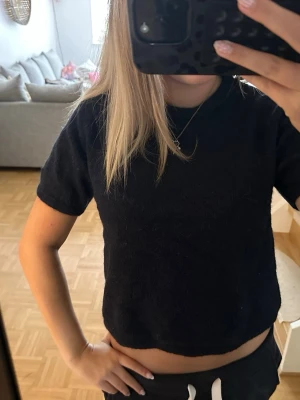 Mörkblå croppad topp med kort ärm - En enkel och stilren Mörkblå croppad topp med korta ärmar. Toppen har en rund halsringning och är tillverkad i ett mjukt material som känns bekvämt mot huden. Perfekt att matcha med både jeans och kjol för en avslappnad look.