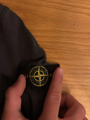 Mörkblå t-shirt från Stone Island - Snygg mörkblå t-shirt från Stone Island Junior med den klassiska kompassloggan på ärmen. Tillverkad i mjuk bomull som känns skön mot huden. Perfekt för dig som vill ha en stilren och trendig look.