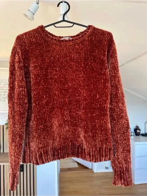 Rostbrun chenilletröja Sincerely Loved - Mysig rostbrun stickad tröja från Sincerely Loved i mjuk chenille. Tröjan har rund halsringning, långa ärmar och ribbade muddar vid ärmslut och nederkant. Perfekt för kalla dagar och ger en trendig look.