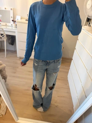 Blå stickad tröja från Saint Tropez - Snygg blå stickad tröja från Saint Tropez med rund halsringning och ribbade muddar vid ärmslut och nederkant. Enkel och stilren modell.