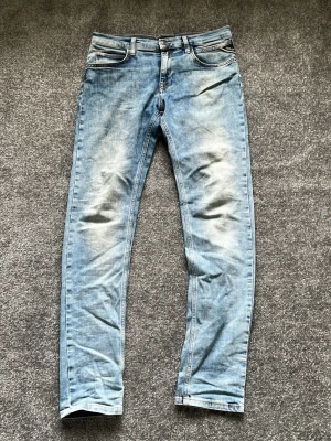 Blåa Replay Zikry - Säljer nu dessa lite schysstare ljusblåa Replay jeans i modell Zikry. Skick:7/10. Inga defekter förutom sliten läderlapp på baksidan som synes på bild fyra. 