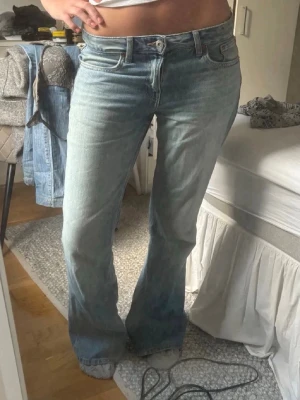 Ljusblå bootcut jeans - Midjemått: 42cm tvärsöver.                             Innerbenslängden: 80cm.                              Lite slitna där nere som man kan se på bild 3
