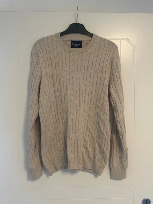 Beige kabelstickad tröja - Kabelstickad tröja från Bondelid i beige med rund halsringning och långa ärmar. Tröjan har ribbade muddar vid ärmslut och nederkant. Perfekt för lager på lager och enkel att matcha med olika stilar. Perfekt skick🙌
