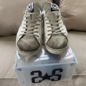 Vit-grå sneakers med stjärndetalj 2stars - Säljer ett par vita sneakers från 2Star som jag har slutat använda pga dom är för små. Jag köpte dom nya för runt 1600kr. Dem är i mycket fint scick och kommer med box och extra snören! Hör bara av dig vid funderingar eller något annat!! Priset är ej hugget i sten!!!