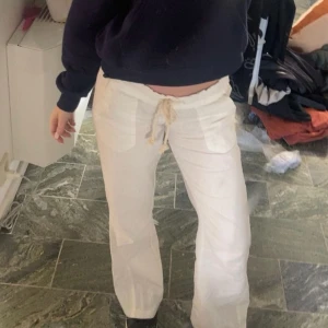 Vita linnebyxor från Roxy med snörning - Säljer ett par  vita linnebyxor från Roxy med resår i midjan och snörning framtill. Byxorna har raka ben, stora fickor fram och är gjorda i mjukt linne som är perfekt för varma dagar. Sköna och luftiga, passar dig som gillar avslappnad stil.