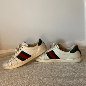 Gucci Ace skor - Säljer nu mina fina Gucci ace skor i storlek 43 med lyxiga detaljer som alligator skinn i hälen. Dustbag, låda men även kvitto medkommer. Använt skick. Hör gärna av dig vid vidare funderingar.
