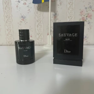 Dior Sauvage Elixir 100ml parfym - Dior Sauvage Elixir är en exklusiv herrparfym i en elegant, mörkblå glasflaska med silverdetaljer. Flaskan rymmer 100 ml och kommer med original svart kartong. Doften är intensiv och maskulin, perfekt för dig som vill sticka ut med en lyxig och modern känsla.