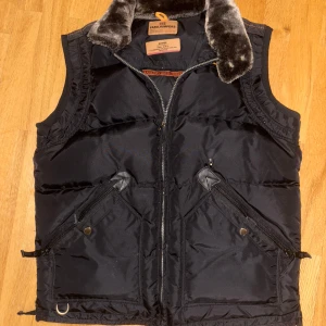 Parajumpers Masterpiece Series väst XL – sällsynt modell - Gammal modell som är slutsåld idag. Storlek XL Mycket bra skick, inga tecken på användning.  Litet hål över höger ficka finns - som kan ses på bilderna. Vid snabb affär kan priset diskuteras annars så gäller original priset har ingen brådska med att sälja den😊                                                       Kan även tänka mig ett byte mot något i likvärdigt värde