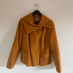 Senapsgul lyxig kappa  - Kappan har tjockt lyxigt material med silke på insidan🧡 Knapparna är välgjorda och går att knäppa🧡 Lite osäker på storlek men skulle säga att den passar S-L🧡 Helt oanvänd🧡