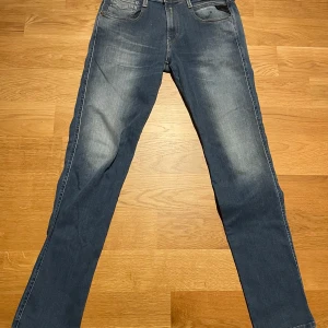 Replay Anbass Hyperflex  blå - Snygga Replay Anbass Hyperflex jeans i blå  med lätt slitning på låren. Strl 29