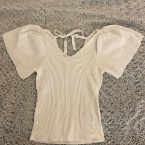 Vit ribbad topp med puffärmar och knyt - Säljer denna jättefina vita toppen ifrån Vero Moda, som inte riktigt kommer till användning för mig..