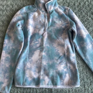 Blåvit fleece från The North Face - Supermjuk fleece från The North Face i blått och vitt tie dye-mönster. Fint skick och perfekt för lite kallare dagar!❄️