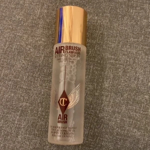 Charlotte Tilbury Airbrush Setting Spray - Airbrush Flawless Setting Spray från Charlotte Tilbury i en genomskinlig flaska med guldig kork. Innehåller 100 ml och ger en fräsch finish som håller sminket på plats upp till 16 timmar. Perfekt för att fixera din makeup och undvika att den smälter eller försvinner under dagen.