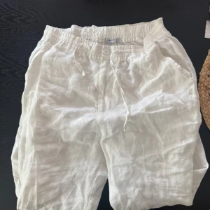 Vita linnebyxor med snörning från Akry - Snygga och luftiga vita linnebyxor från Akry med elastisk midja och snörning. Sjukt snygg vit färg som utviker att man ser igenom (som många söker i linnebyxor). Dem är aldrig använda och är såklart i bra skick, pris kan diskuteras!!