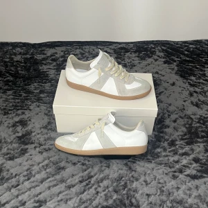Maison Margiela Gats - Tja! Säljer nu dessa galet eftertraktade Maison Margiela Gatsen i färgen ”White Gum” med allt OG (Box, Dustbags), Size 44,5, Fits=44! Vi på SK Clothing Garanterar att de är autentiska. Ett av två äkta par på marknaden, har legit checkat de på Legit Grails, se ovan bild 2,(kan skickas privat)! Toppenskick utan några defekter alls, (9,5/10)! Om du själv har något annat sätt att bekräfta att de är autentiska är det bara att skriva så löser vi det! Hör av dig vid minsta fråga eller fundering!🌟