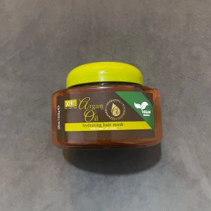 Argan Oil hydrating hair mask - En återfuktande hårinpackning med arganolja från XHC. Kommer i en rund burk med gul lock och bruna detaljer. Vegansk formula som ger näring och glans till håret. Innehåller 220 ml och passar dig som vill boosta håret med extra fukt.