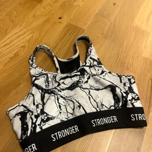 Svartvit sporttopp från Stronger - Sportbh från Stronger, vadderingen i är borttagen men går att sätta i nya om man vill.