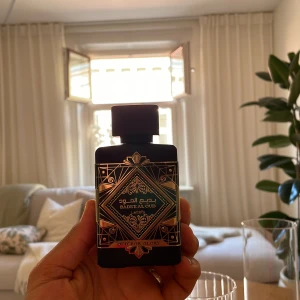 Badee Al Oud Oud For Glory parfym - Badee Al Oud Oud For Glory från Lattafa är en lyxig parfym i svart flaska med guldiga detaljer och orientaliskt mönster. Doften har tydliga inslag av oud, varm krydda, patchouli och läder, vilket ger en djup och mystisk känsla. Perfekt för dig som gillar intensiva och unika dofter.