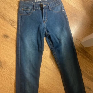 Mörkblå midwaist jeggings - Snygga mörkblå jeggings med midwaist passform och klassiska jeansfickor. Byxorna har smal siluett och stretchigt material som sitter tajt men bekvämt. Perfekta för dig som gillar en enkel och stilren look.