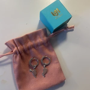 Silverörhängen från L8H - Säljer ett par snygga silverörhängen från l8hasselblad . Örhängena har små creoler med glittriga detaljer och berlocker i form av två halva hjärtan. Kommer med original ask.