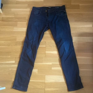 Mörkblå Replay Anbass jeans, stl 31 - Säljer ett par mörkblå Replay Anbass jeans i klassisk femficksmodell. Jeansen har slim passform och raka ben, tillverkade i mjukt denimtyg. Perfekta för dig som gillar stilrena och tidlösa jeans med snygg tvätt. Byxorna är varsamt använda och i väldigt gott skick, inga flaws. Hör av dig vid funderingar. 